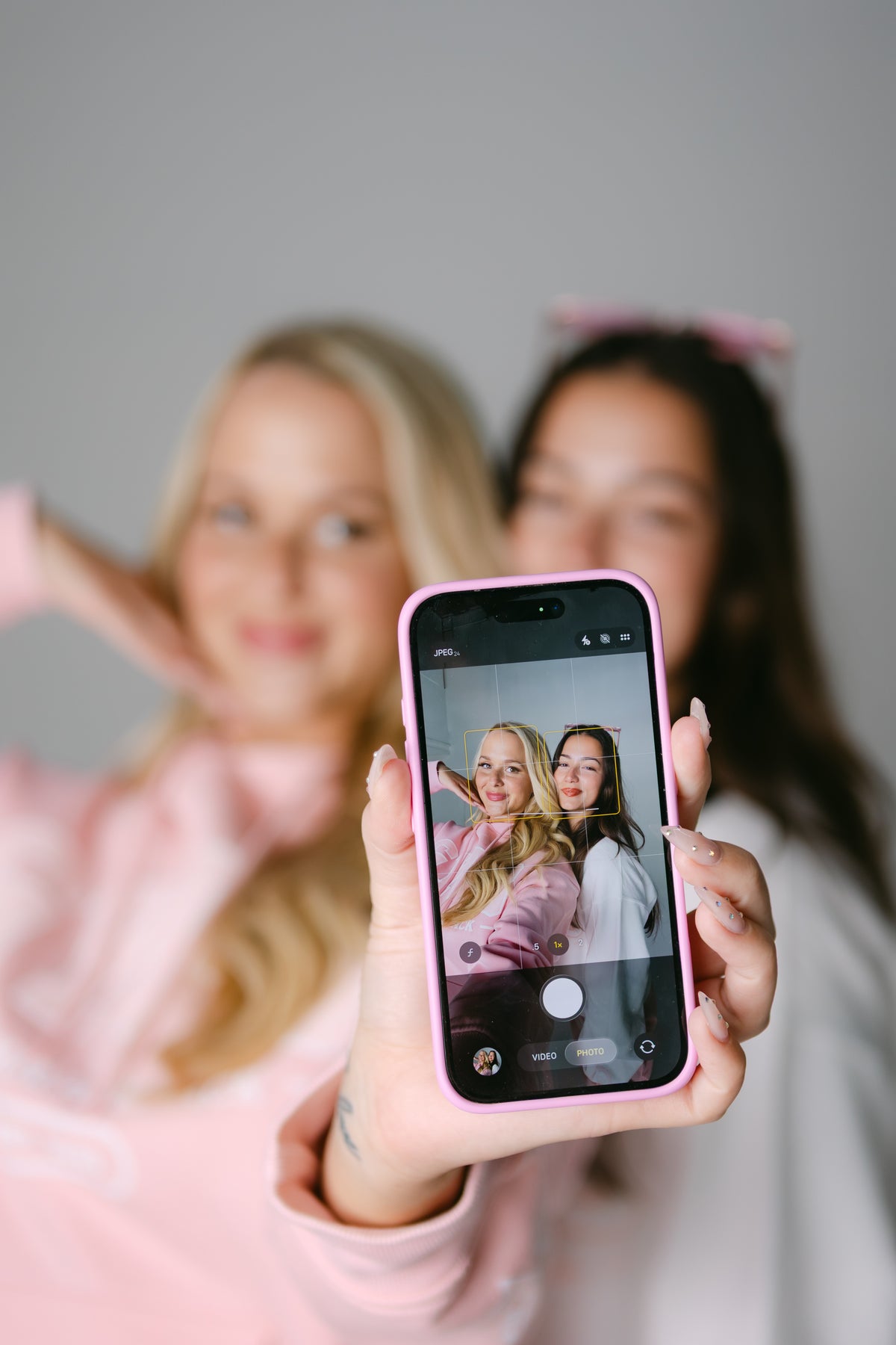 Two women taking a selfie in GYPB sweatshirts