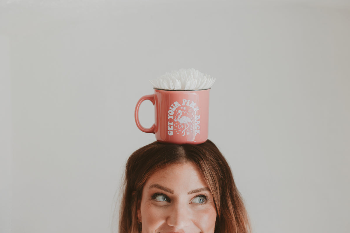 Lindsey balancing a Get Your Pink Back mug on her head